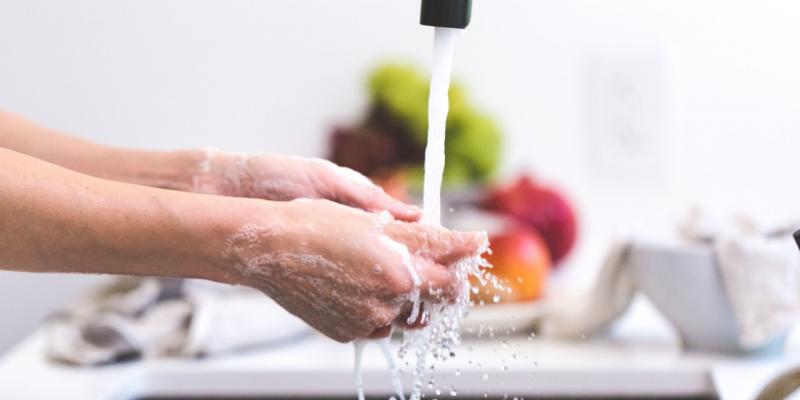 A person washes their hands in a sink