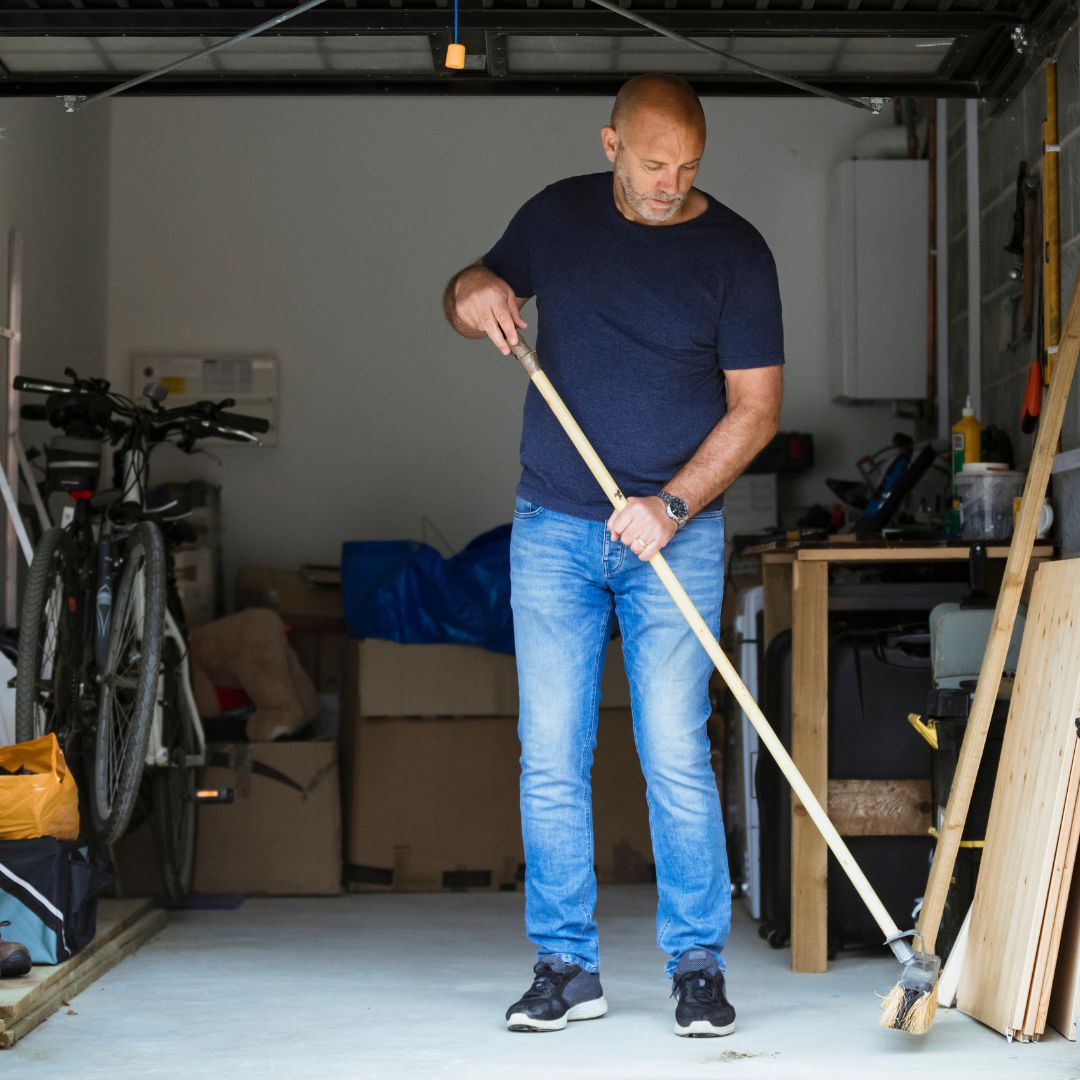 man sweeping garage